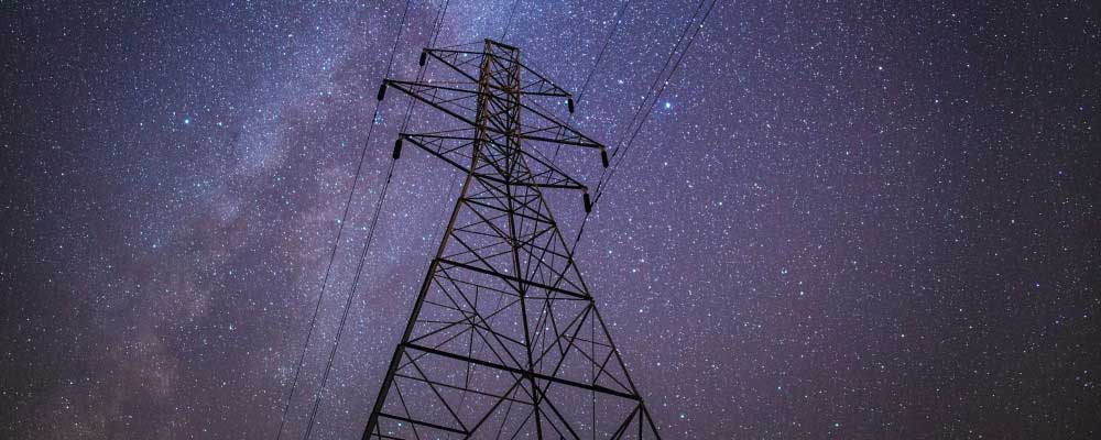 Electrical Power Tower Behind a Star Filled Sky
